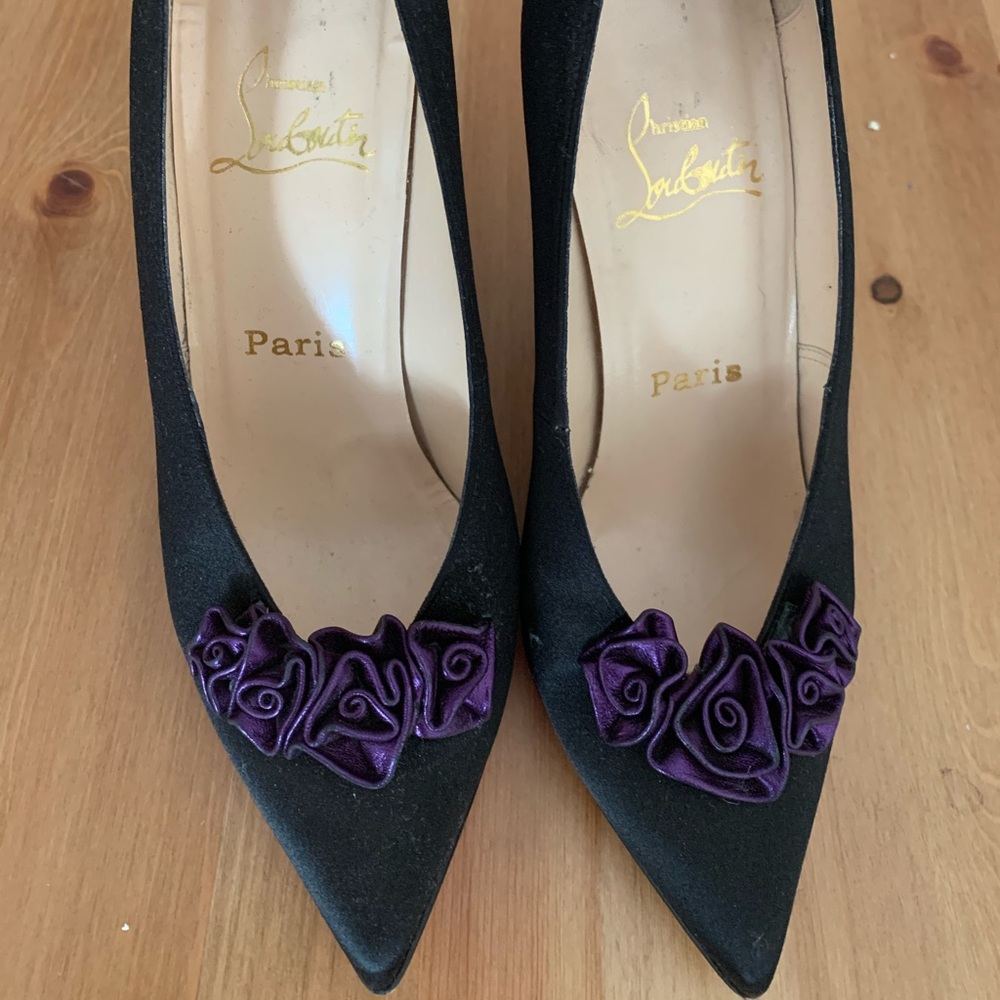 Black satin Louboutin heels with purple flowers
